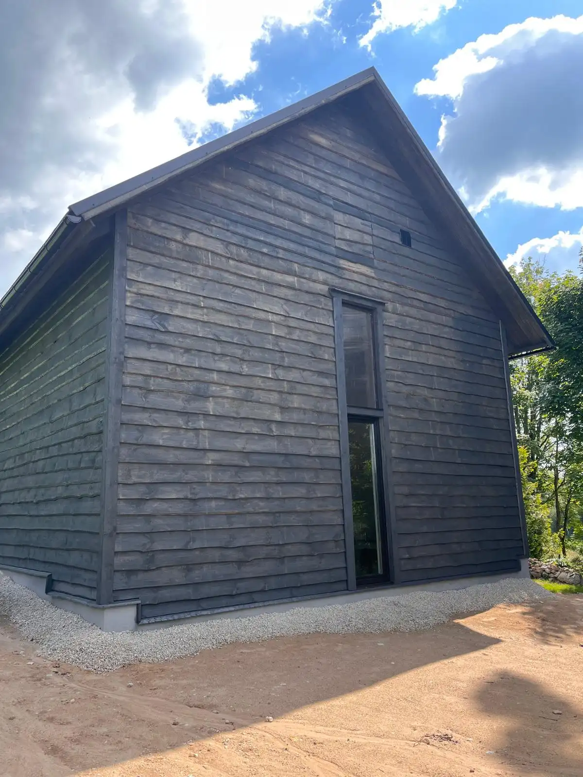 Finished extension with dark cladding and a tall narrow window