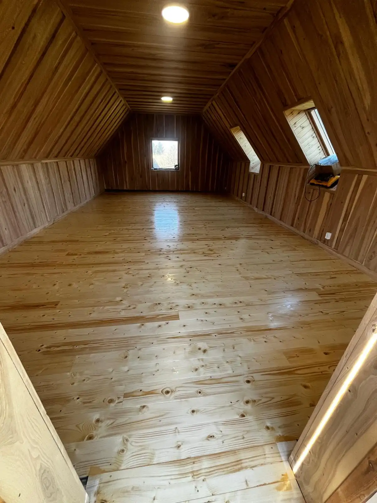 Attic room with ash cladding on the walls and a lacquered pine floor