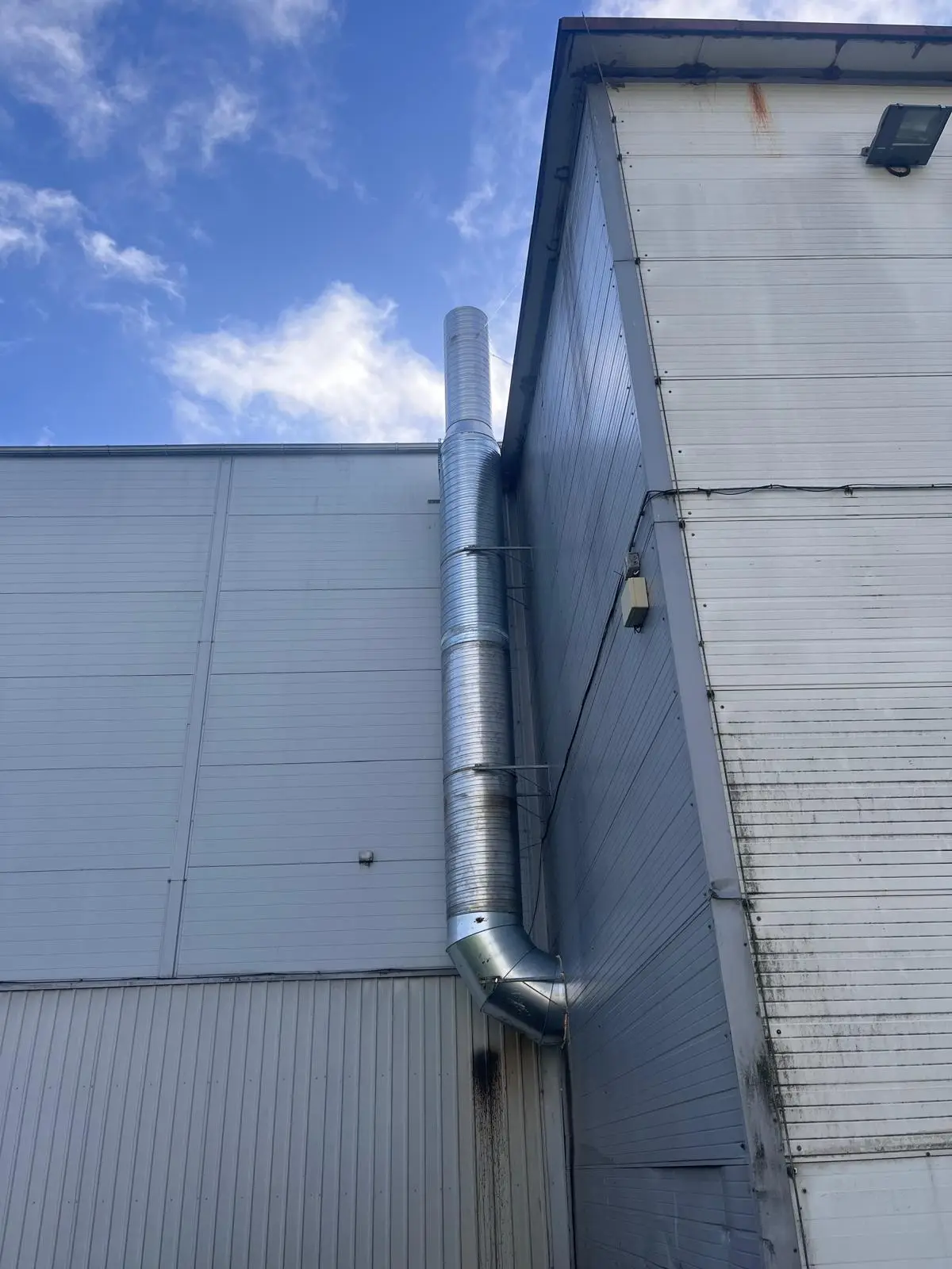 Tööstushoone ventilatsioonikorsten ja uus toruühendus seina ääres