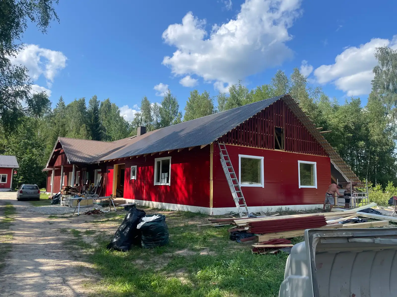 Timber-framed extension with red board cladding and roof battens